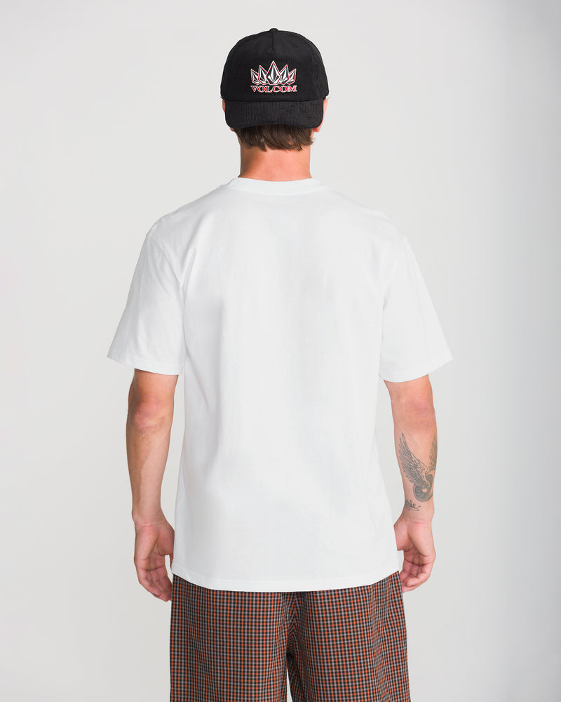 Back view of a person wearing a Volcom Men’s Remastered Stone Short Sleeve Tee, a black baseball cap, and brown plaid shorts.