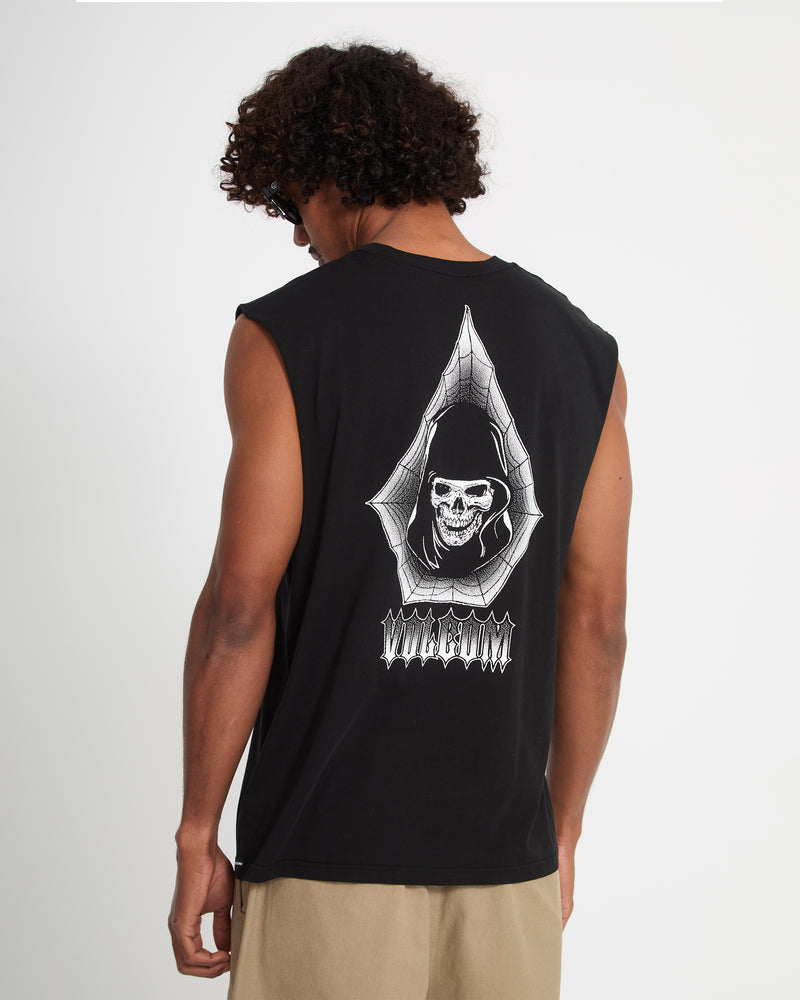A man with curly hair wears sunglasses and the Volcom Men's Gamma Doom Sleeveless—black with a white hooded skull in a spiderweb graphic on the back—paired with beige shorts.