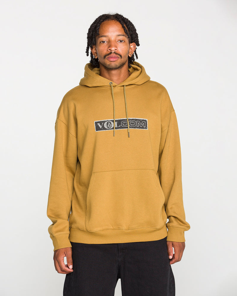 A person wearing the Volcom Men's Super Stoned Pullover in mustard yellow, crafted from brushed-back fleece, paired with black pants, stands against a plain white background and looks at the camera.