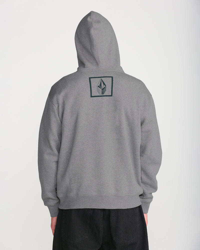 A person wearing the Men’s Quadratic Pullover by Volcom in gray, hood up, seen from the back. Made of recycled fibers with a small black leaf logo inside a rectangle on the upper back. Paired with black pants.