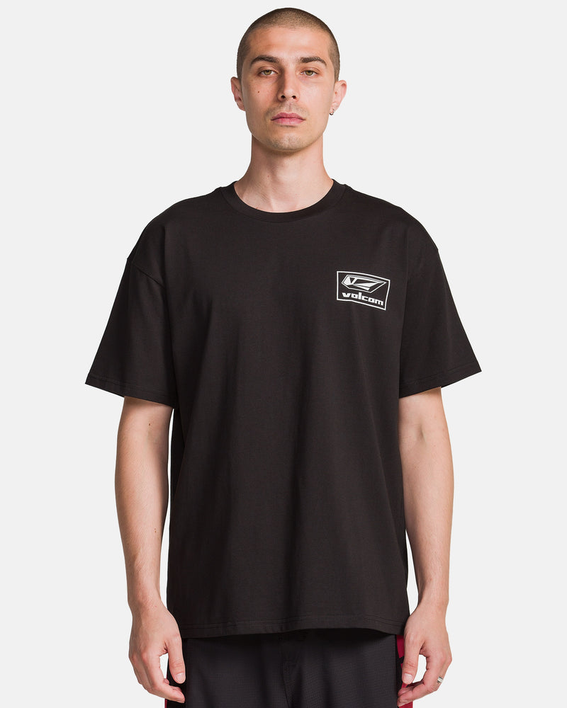 A man with short hair wears the Volcom Men's Surf Vitals Modstone Short Sleeve Tee, a loose fit made from premium ringspun cotton with a small white Volcom logo on the left chest, standing against a plain white background.
