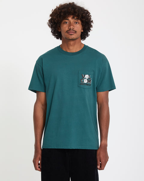 A man with curly hair wears the Volcom Men's Parted Out Pocket Short Sleeve Tee in green.