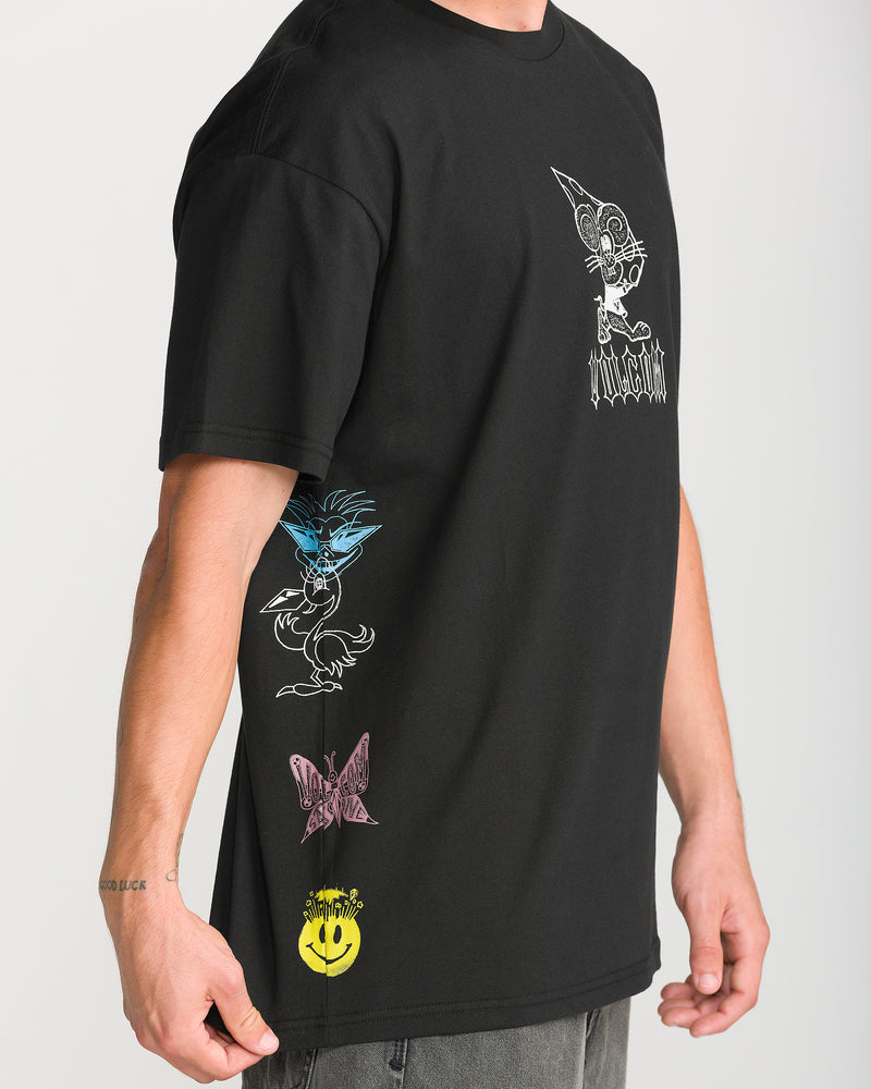 A person wears a black Volcom Men’s Featured Artist Casey Jones Short Sleeve Tee made of heavyweight premium cotton, featuring side-printed graphic illustrations of a cartoon character, a butterfly, and a smiley face.