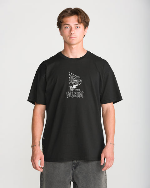 A man wears a black Men’s Featured Artist Casey Jones Short Sleeve Tee by Volcom, featuring a white line-art graphic of a cartoon cat in a pizza-slice hat above gothic-style text.