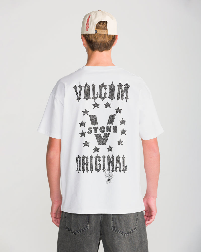 A person seen from behind wears a white Men’s Featured Artist Casey Jones Short Sleeve Tee featuring a black graphic on the back with the text VOLCOM STONE ORIGINAL, stars, and a Casey Jones cartoon character.