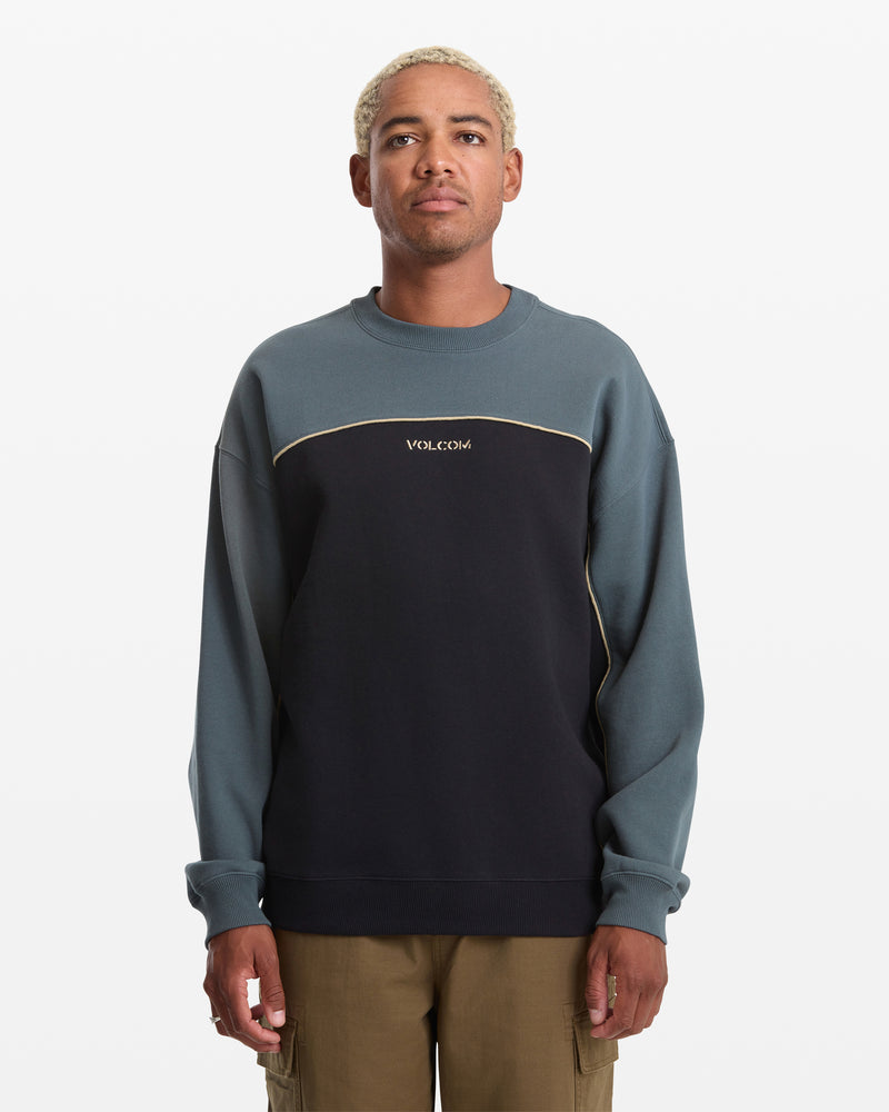 Man wearing a two-tone sweatshirt with 'Volcom' branding on a white background