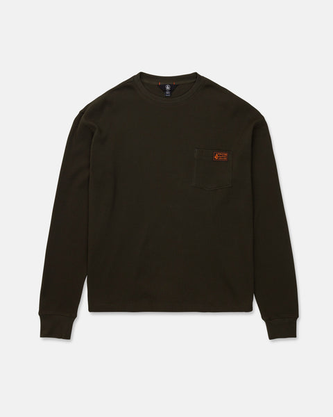 The Volcom Men's Overtime Workwear Thermal Long Sleeve Shirt is shown laid flat on a white background. This dark green, ribbed shirt features classic workwear styling with long sleeves, a crew neckline, and a small chest pocket adorned with a brown rectangular patch.