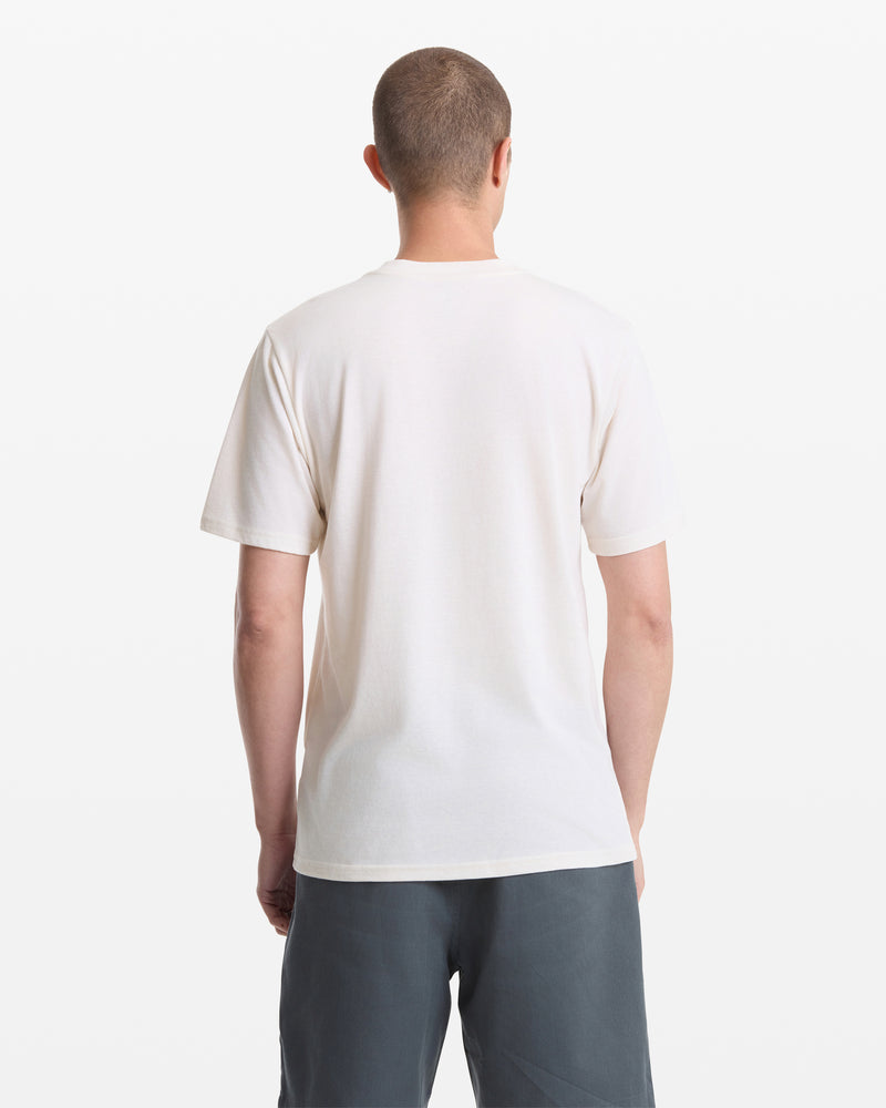 A person with short hair is seen from behind wearing a Volcom Men's Sunnies Short Sleeve Tee in white and dark gray shorts, standing against a white background.