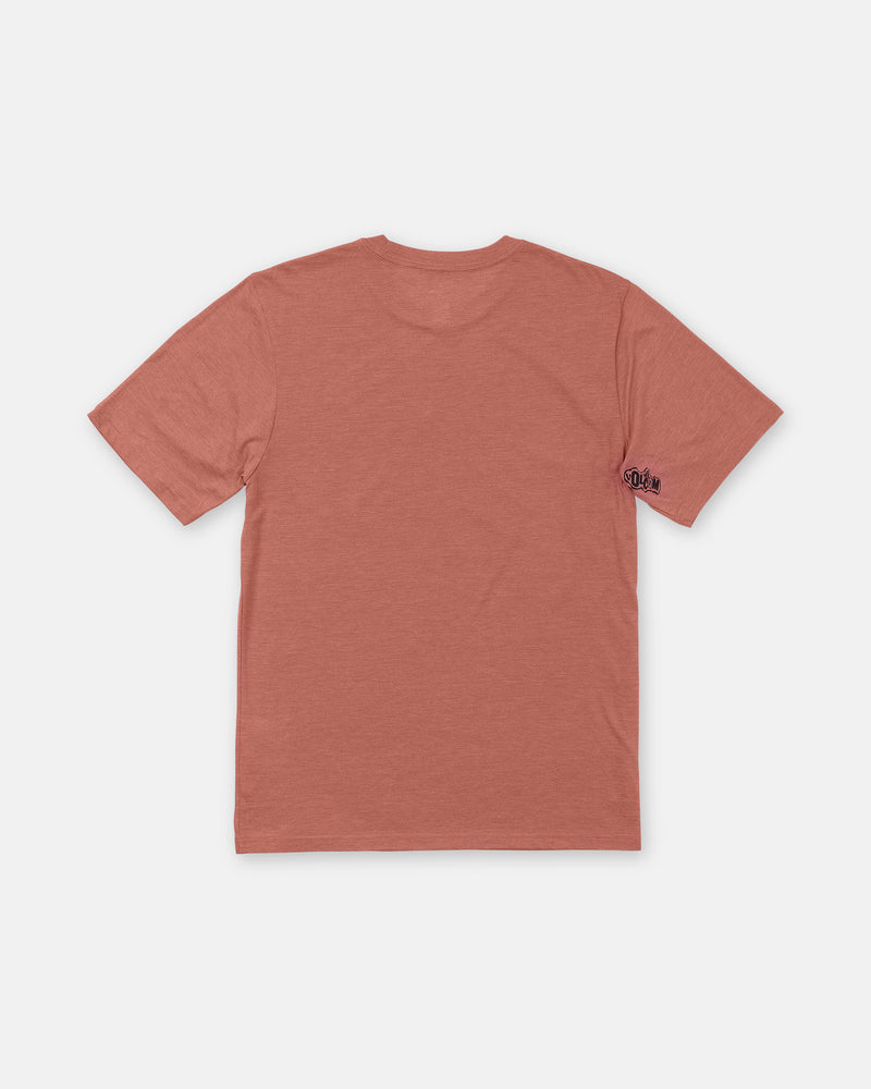 A Men’s Core Stone Short Sleeve Tee by Volcom in dusty rose heather, shown from the back with a small dark logo on the left sleeve. The comfy crew neck shirt is laid flat on a white background.