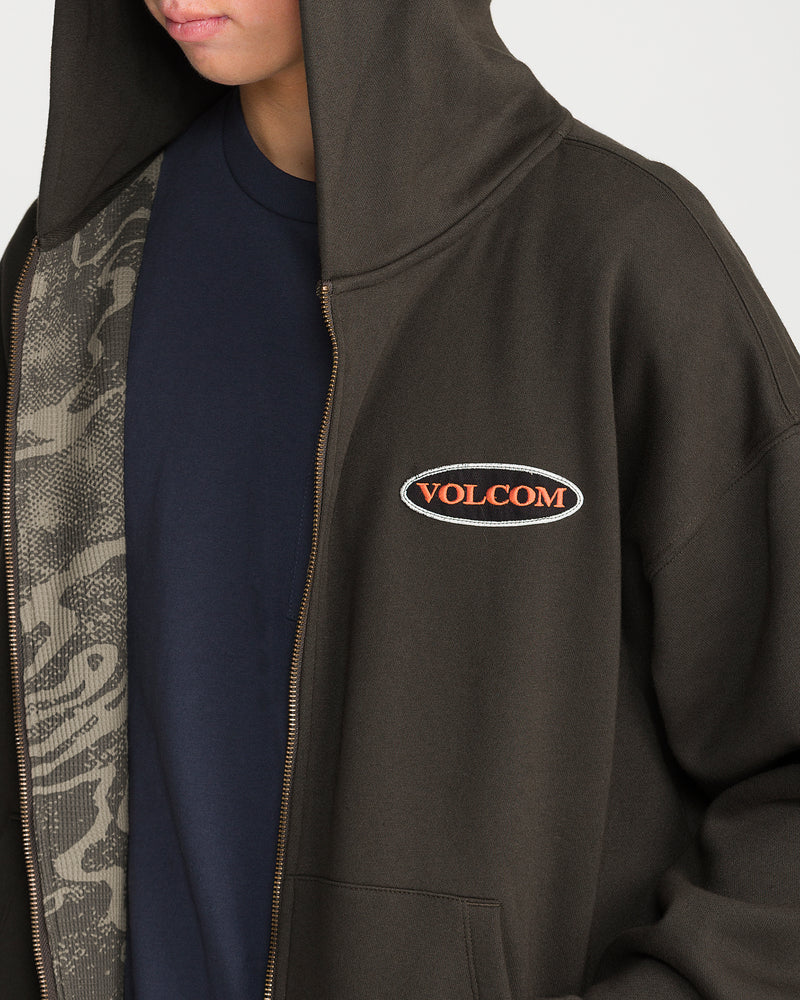 Volcom Men’s Driggs Workwear Zip dark brown zip-up hoodie featuring an oval patch with orange text on the chest and a gray thermal lining.