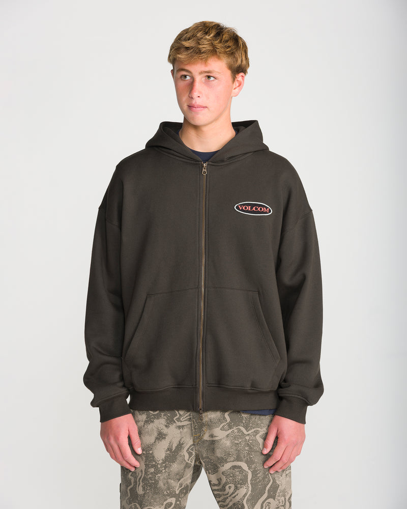 A person wearing a dark olive green Volcom Men’s Driggs Workwear Zip hoodie with an oval brand logo on the chest.