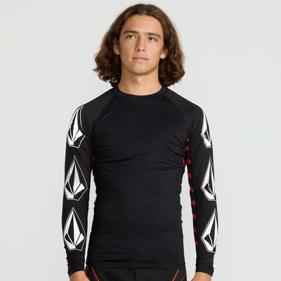 Person wearing a black long-sleeve shirt with geometric patterns on a light gray background