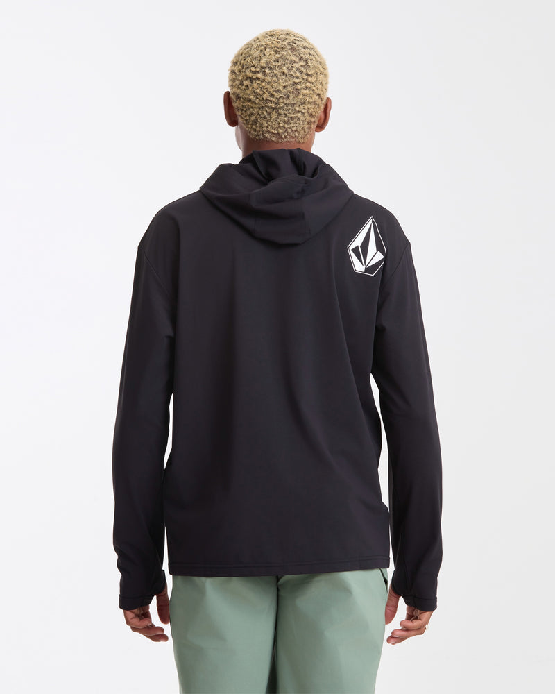 A person with short, curly blond hair is facing away from the camera, wearing light green pants and a Volcom Men's Pullover Hood Long Sleeve in black featuring a white geometric logo on the back left shoulder, set against a plain background.