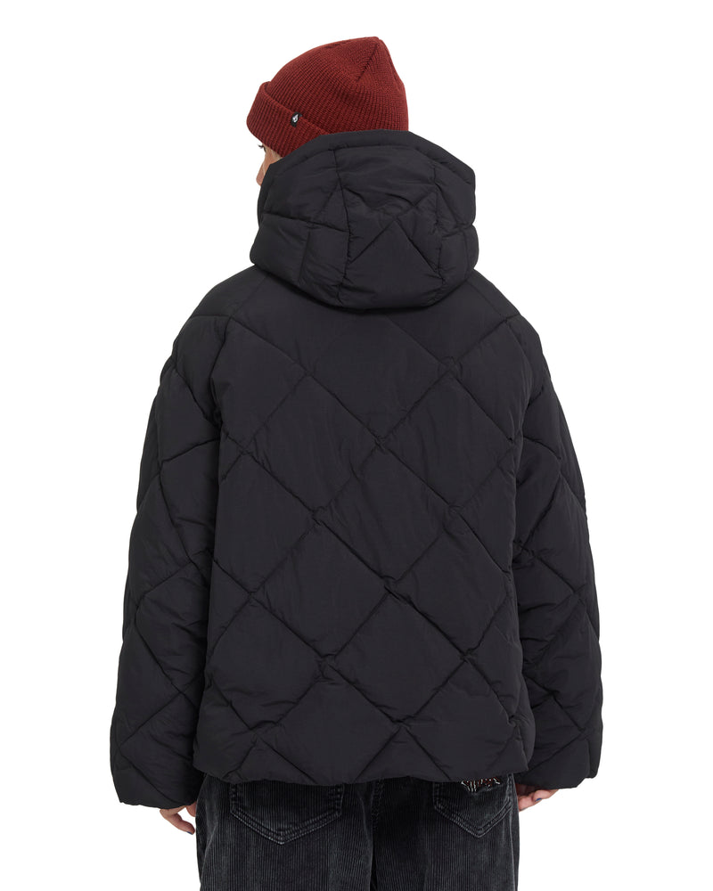 Back view of a person wearing a black Volcom Women’s Out Of Boxy Puff quilted heavyweight puffer jacket with a hood and a dark red beanie.