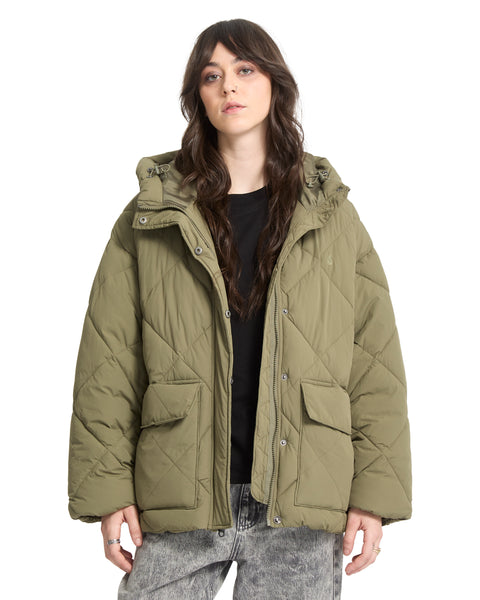 A person wears an olive green, cropped heavyweight Volcom Out Of Boxy Puff jacket featuring a hooded design, two front pockets, and a snap-button closure.