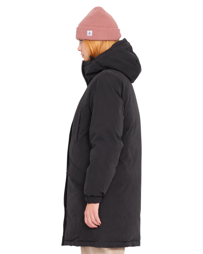 A person in profile wears a pink knit beanie and a black Volcom Women’s Sleepi Puff Up Parka.
