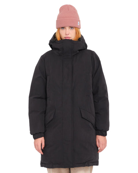 A person wearing a relaxed fit, heavyweight Women’s Sleepi Puff Up Parka by Volcom and a pink beanie.