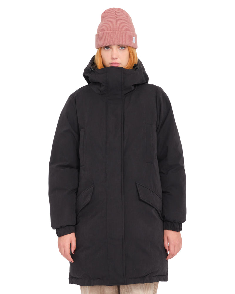 A person wearing a relaxed fit, heavyweight Women’s Sleepi Puff Up Parka by Volcom and a pink beanie.