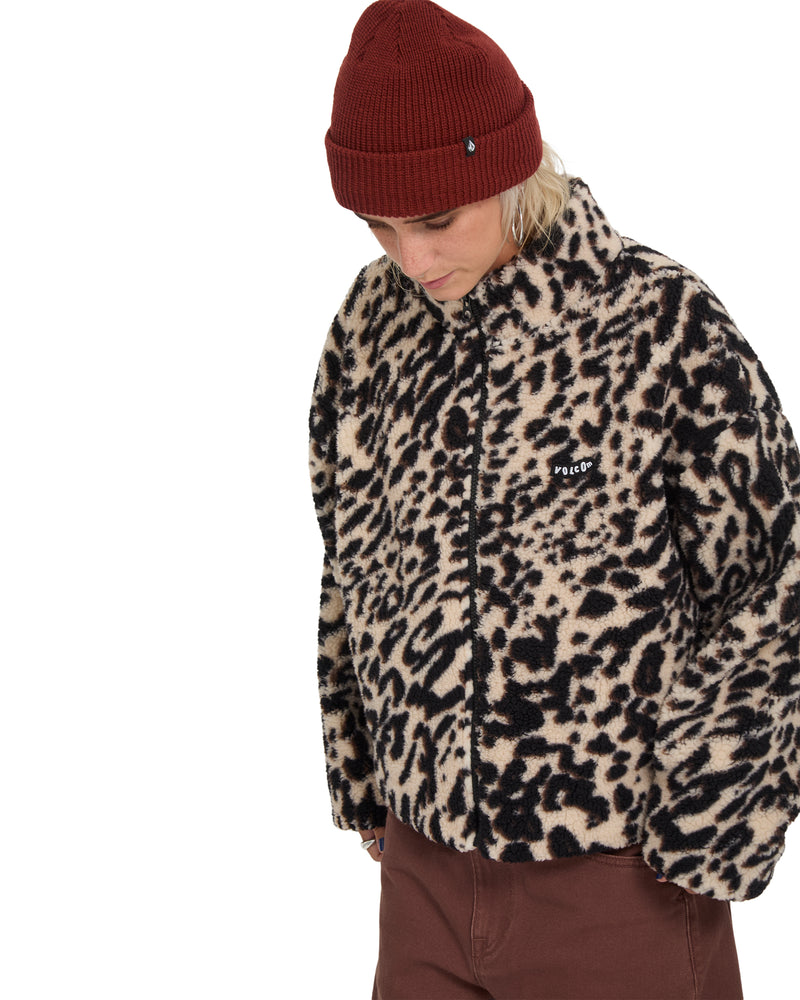 A person wearing an oversized leopard-print Wylding Out Sherpa by Volcom and a maroon beanie.