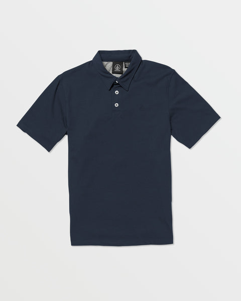 The Volcom Kids' Wowzer Polo Short Sleeve Tee is a navy blue modern fit shirt with a collar, three white buttons, and short sleeves, made from a comfy cotton-poly blend and shown laid flat on a white background.