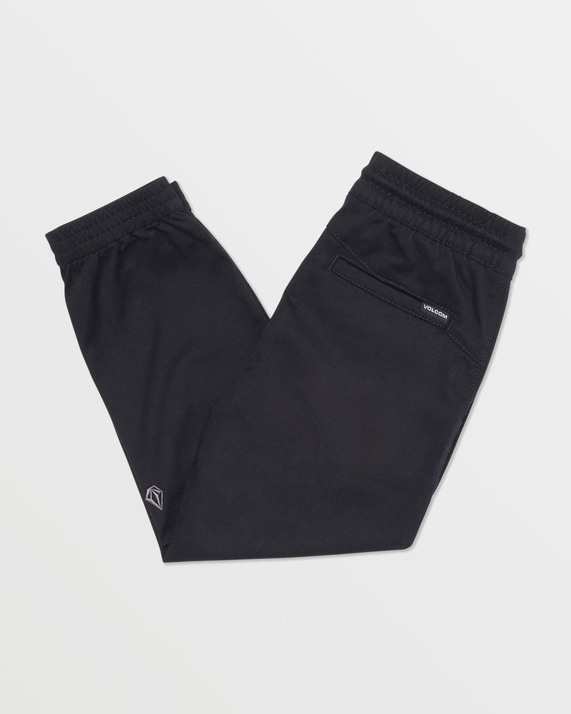 Volcom Kids' Big Boys Frickin Slim Joggers in black, made with recycled fibers, feature an elastic waist and cuffs, a small ankle logo, and a zippered upper pocket. Pants are shown neatly folded on a white background.