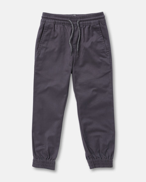The Volcom Kids' Big Boys Frickin Slim Joggers in dark gray, made with recycled fibers, feature an elastic waist with drawstring, two side pockets, and elastic ankle cuffs; pants shown laid flat on a white background.