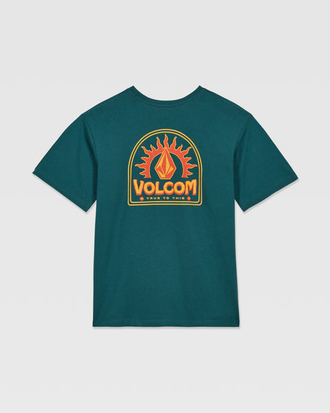 The Kids' Solstice Short Sleeve Tee by Volcom features a dark teal color and a bold back graphic with a stylized flame and “VOLCOM” in orange-yellow above “TRUE TO THIS”—perfect to pair with your favorite Volcom denim or low-rise jeans.