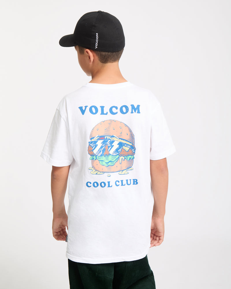 A child in a black cap and the Kids' Burgstone Pocket Tee—an organic cotton shirt featuring a vibrant burger print and "VOLCOM COOL CLUB" on the back—stands against a plain white background.