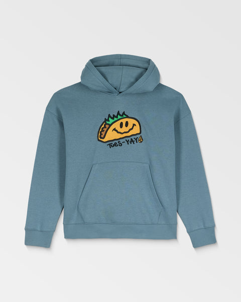 The Volcom Kids' Voltaco Po is a blue hoodie with a graphic of a smiling taco with green toppings and “Tues-Yay!” on the front. It features a front pocket and an adjustable hood with drawstrings.