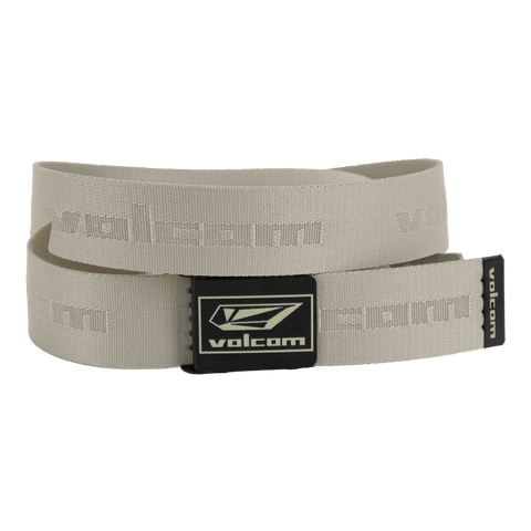 The Volcom Men's Modstone Web Belt in beige is shown coiled, featuring an embossed Volcom logo and a black rectangular metal clamp buckle with the Volcom logo in white.