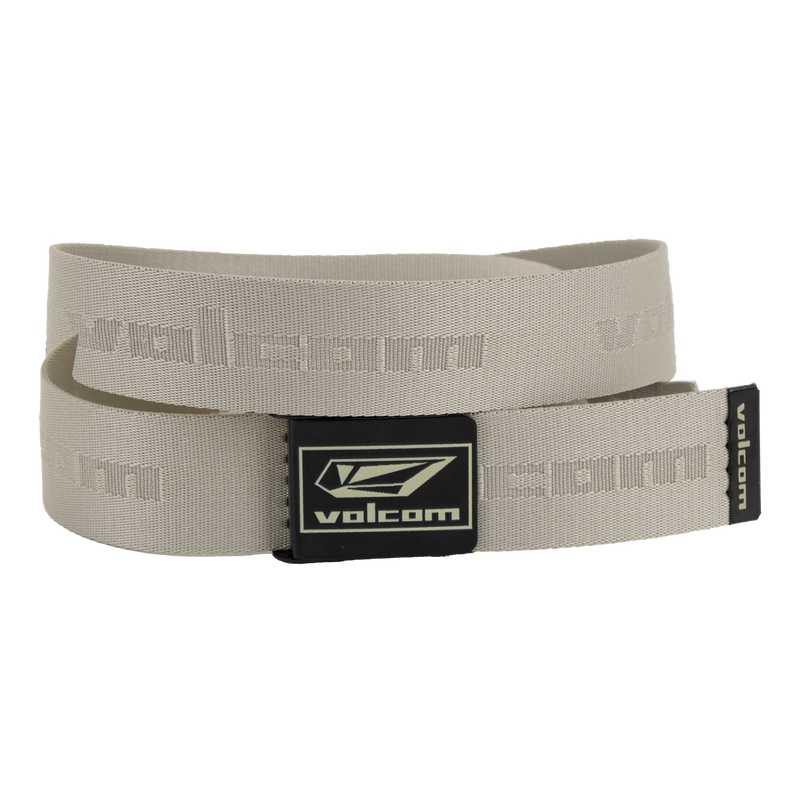 The Volcom Men's Modstone Web Belt in beige is shown coiled, featuring an embossed Volcom logo and a black rectangular metal clamp buckle with the Volcom logo in white.