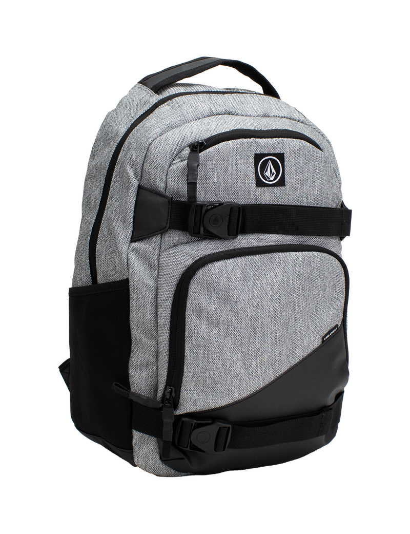 Volcom Men's Grindstone Skate Backpack in gray and black features multiple zippered compartments, side pockets, and a top handle. This backpack includes a logo patch on the front, adjustable straps, and a padded laptop sleeve for added convenience.
