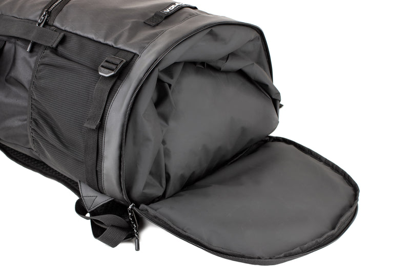A black Volcom Men's Litestone Gear Pack duffel bag is shown with its end compartment open, revealing a spacious, empty interior. The bag features handles, straps, visible stitching, and organized storage for essentials.