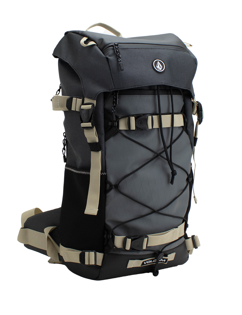 The Volcom Men's Peakstone Mountain Backpack is a durable gray and black daypack featuring beige straps, side pockets, a front bungee cord, and a top handle, shown against a white background.