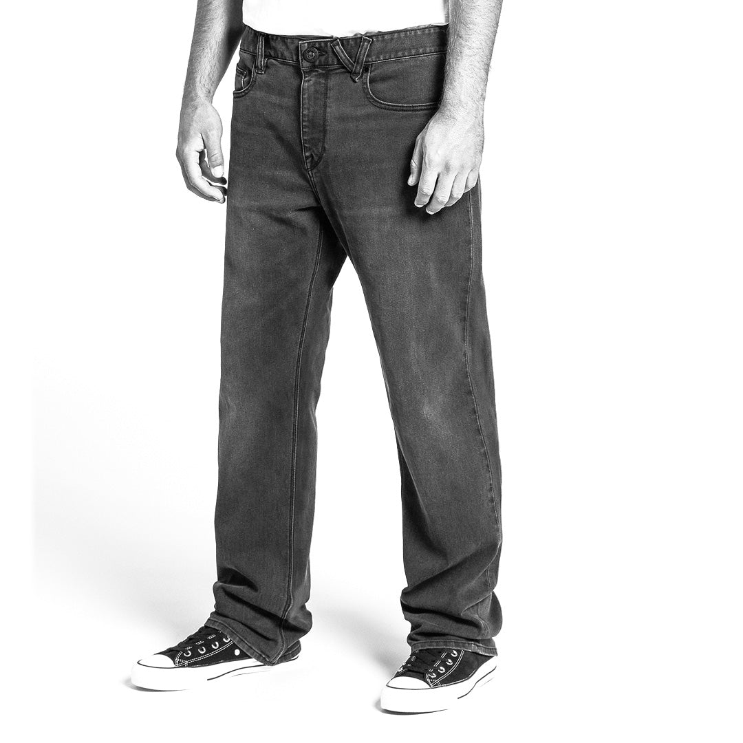 Black and white image of person wearing relaxed jeans and sneakers on a white background