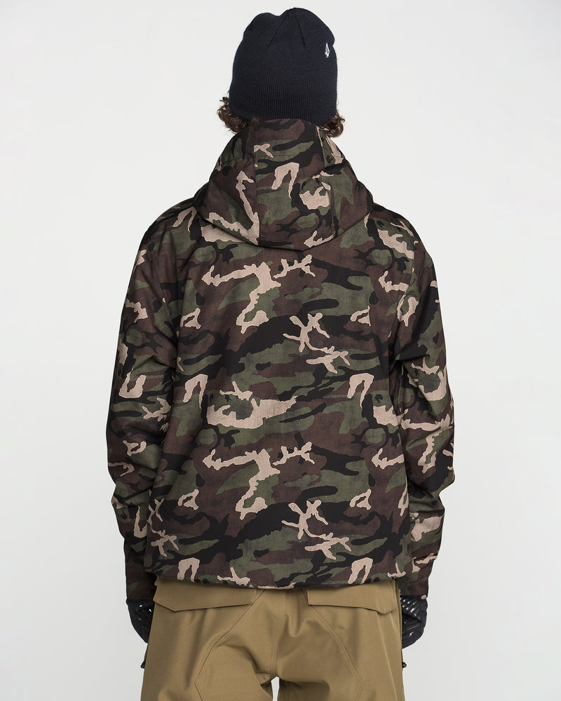 A person wearing a black beanie, tan pants, and the Volcom Men’s Double Insulated Jacket in a camouflage pattern with recycled insulation stands with their back to the camera against a plain white background.