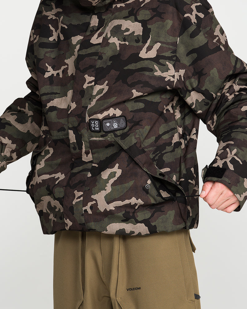 A man wearing the Volcom Men’s Double Insulated Jacket in a camouflage print and khaki pants tightens the elastic drawcord at the hem for an improved fit. Engineered with 10K/10K V-Science fabric for dependable waterproofing and breathability, this technical outerwear also incorporates recycled insulation for sustainable warmth.