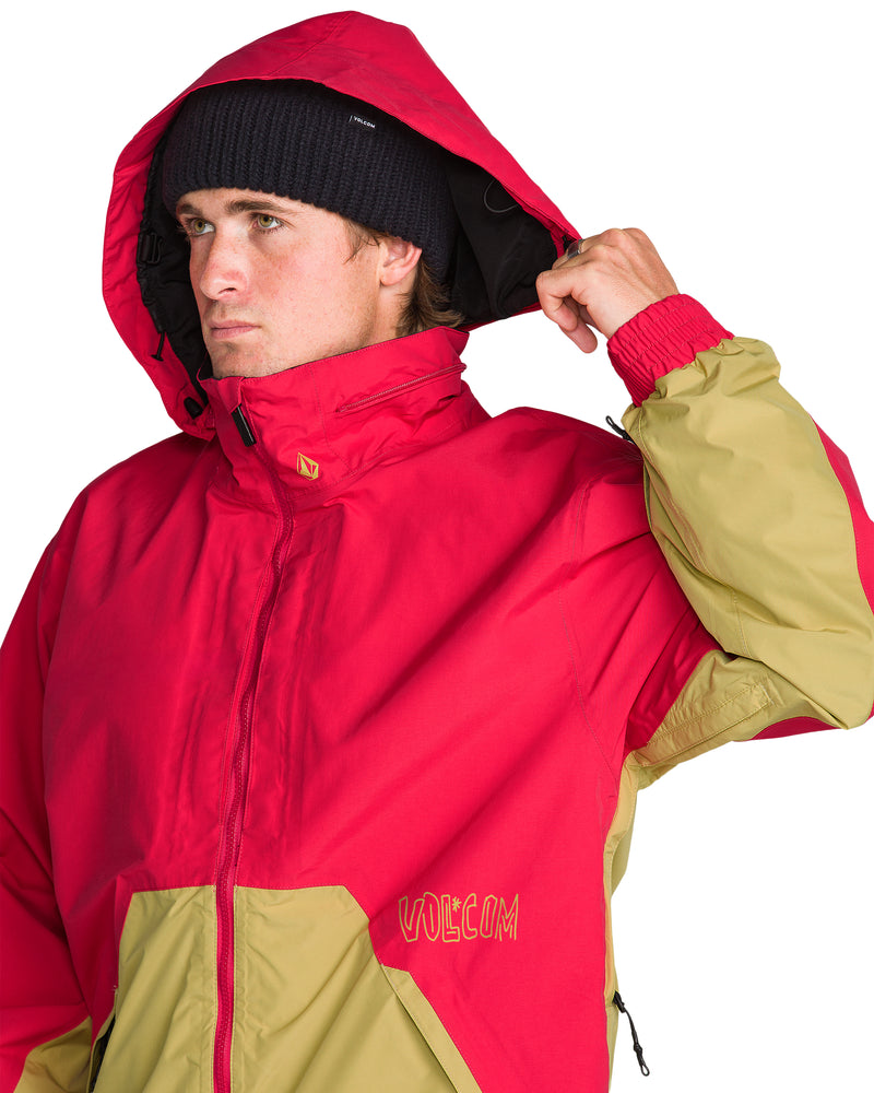 A person wearing a red and tan Men’s Longo Gore-Tex Jacket with the hood pulled up.
