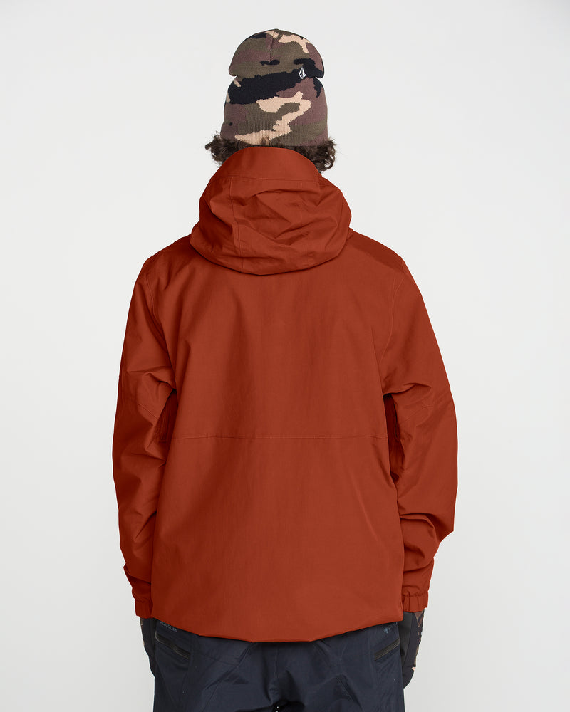 A person is shown from the back against a plain white background wearing the Volcom Men’s L Gore-Tex Jacket in rust, paired with black gloves, dark pants, and a camo-patterned beanie.