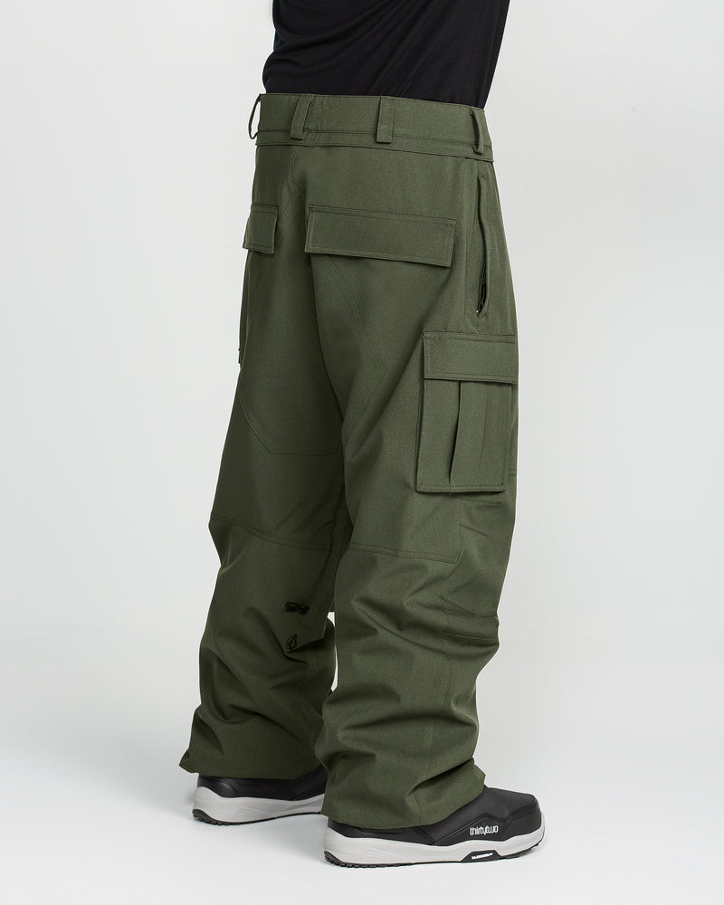 Wearing the Volcom Men’s Nwrk 20K Baggy Pants in olive green with multiple cargo pockets and paired with black sneakers, this look features men’s snow pants that provide a stylishly baggy fit and functional design—set against a plain white background.