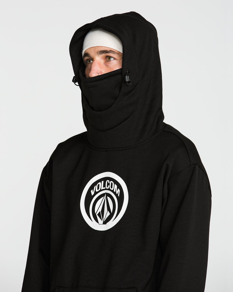 A person wearing the Volcom Men’s Hydro Riding Hoodie in black, featuring a prominent logo on the front, with the hood up over a white beanie, their face partially covered except for their eyes, stands against a plain white background.