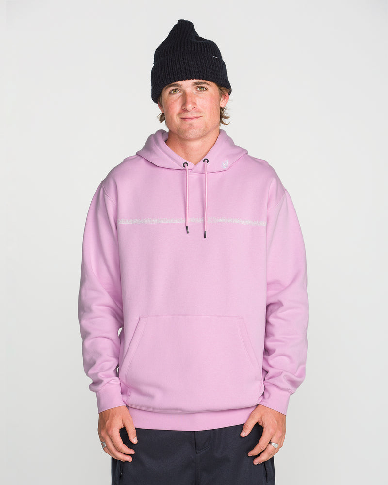 A person wearing a black knit beanie and the Volcom Men’s Essential Hoodie in light pink—crafted from soft cotton-poly fleece with a front pocket—stands facing forward against a plain white background, hands relaxed at their sides.