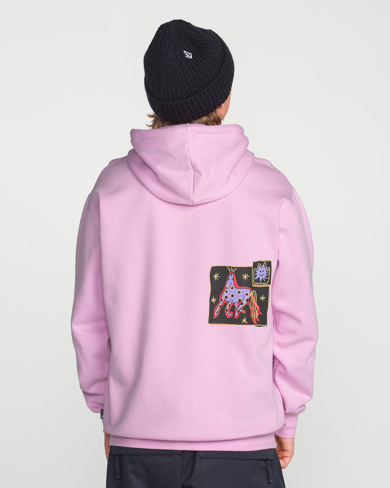 A person facing away, wearing a light pink Volcom Men’s Essential Hoodie made from soft cotton-poly fleece, featuring a colorful abstract patch with stars and shapes on the back—evoking Arthur Longo’s vibrant style—and paired with a black knit beanie. The background is plain and light-colored.