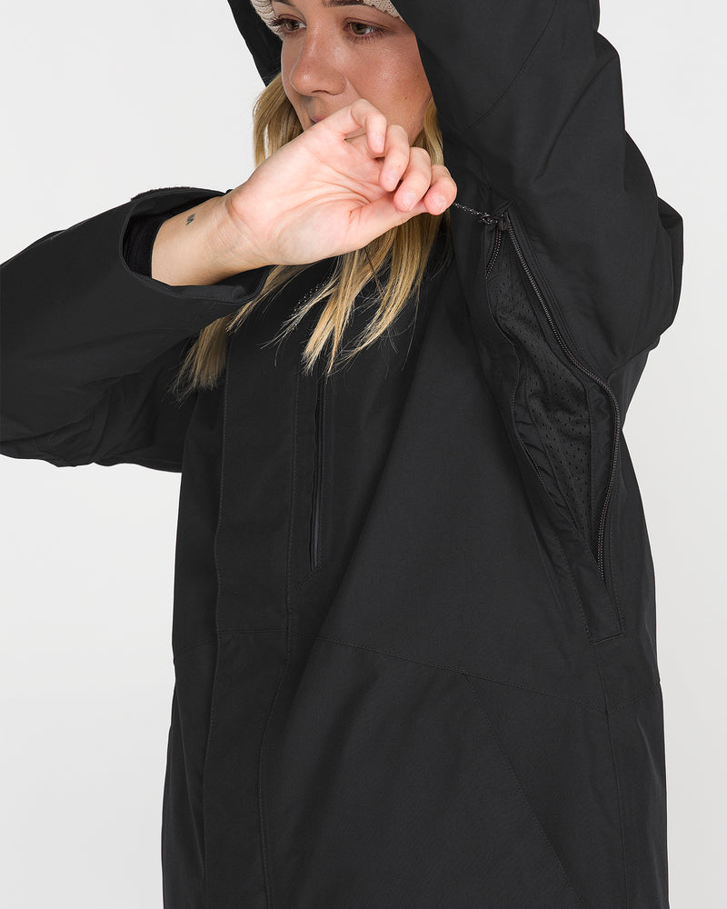 A person wearing the Volcom Women’s Eras Gore Insulated Jacket unzips an underarm vent while raising one arm, partially covering their face.