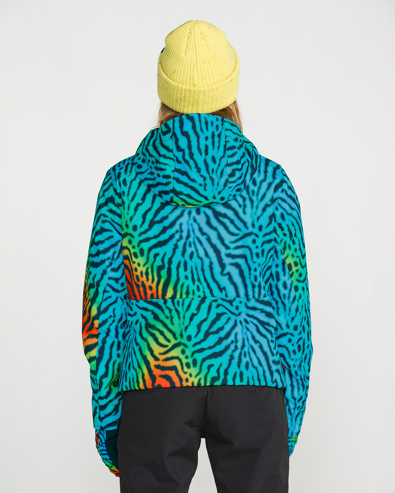 Wearing the Volcom Women’s Bolt Insulated Jacket featuring vibrant blue, green, and orange zebra stripes, and a yellow knit beanie, a person stands facing away against a plain white background.