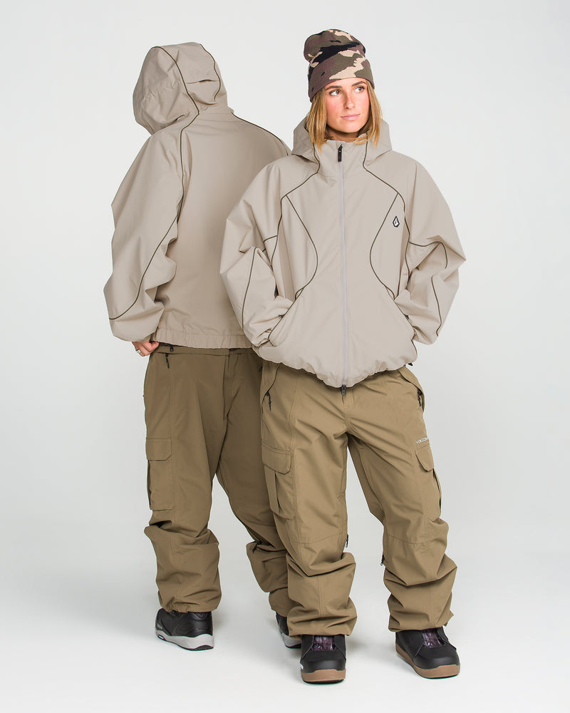 Two people wear the Volcom Unisex Liftline 20K Jacket in a baggy fit, paired with cargo pants and boots against a plain white background; one faces forward with a beanie, while the other stands back-to-back turned away.