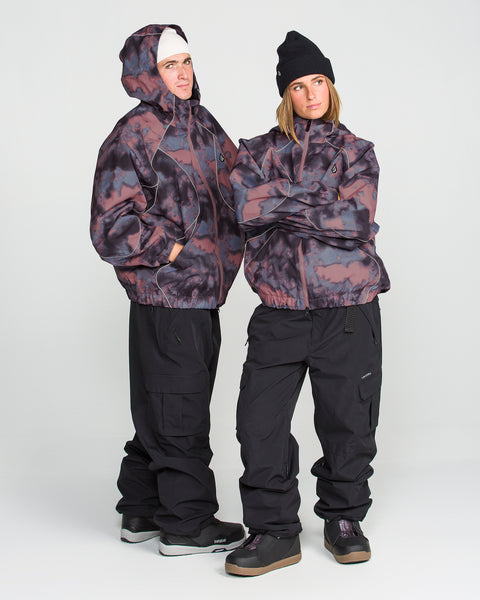 Two people wearing Volcom Unisex Liftline 20K Jackets in bold black and purple tie-dye, paired with black pants, beanies, and sneakers, stand confidently with arms crossed against a plain white background.