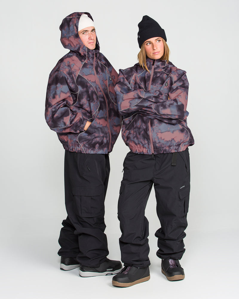 Two people wearing Volcom Unisex Liftline 20K Jackets in bold black and purple tie-dye, paired with black pants, beanies, and sneakers, stand confidently with arms crossed against a plain white background.