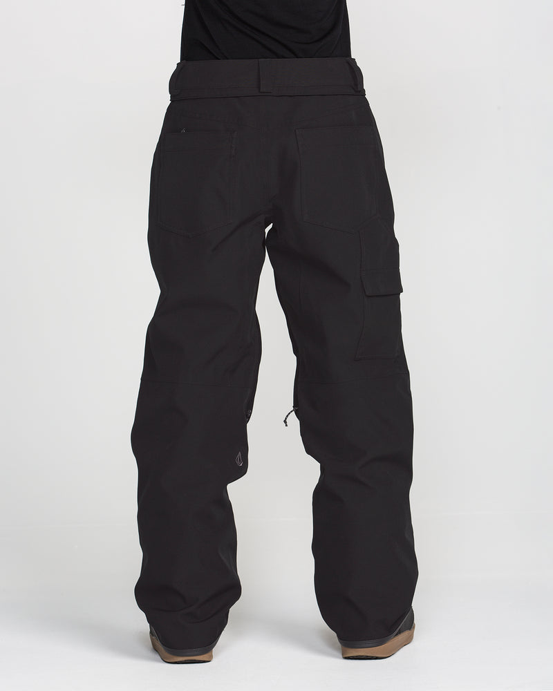 A person is seen from the back wearing Volcom Women’s Pollock Baggy Pants in black—loose-fitting, waterproof, and featuring multiple pockets—standing against a plain white background.