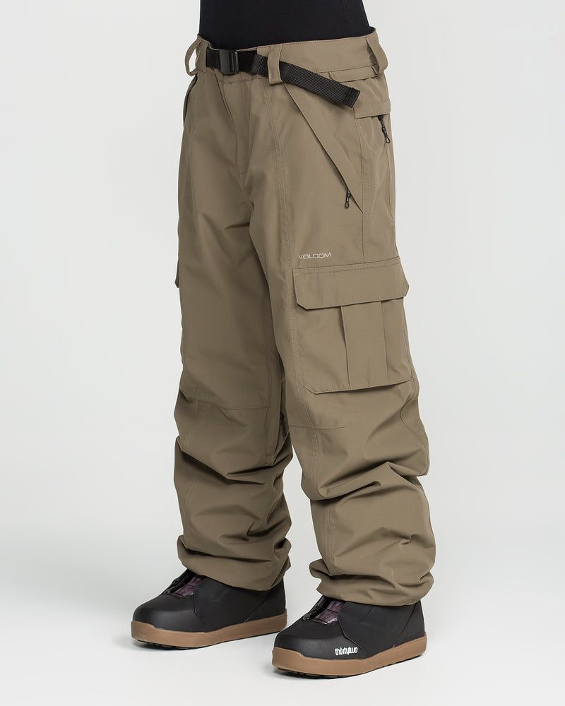 A person is wearing Volcom’s Unisex Liftline 20K Pants—loose-fit, khaki cargo snow pants made with recycled fabric, featuring a built-in belt and zippered pockets. They are paired with black snow boots against a plain white background.